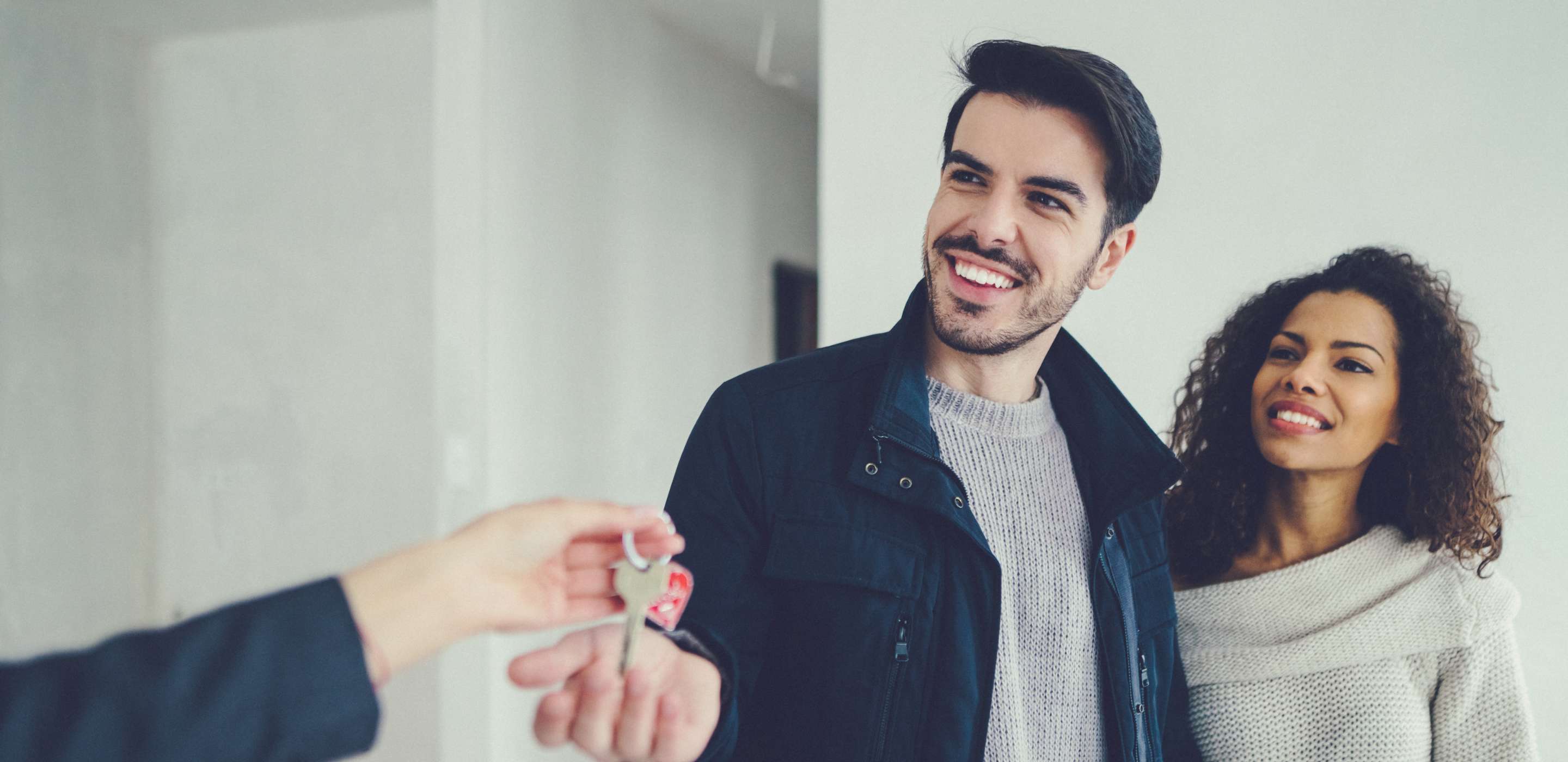 young smiling couple receiving house keys