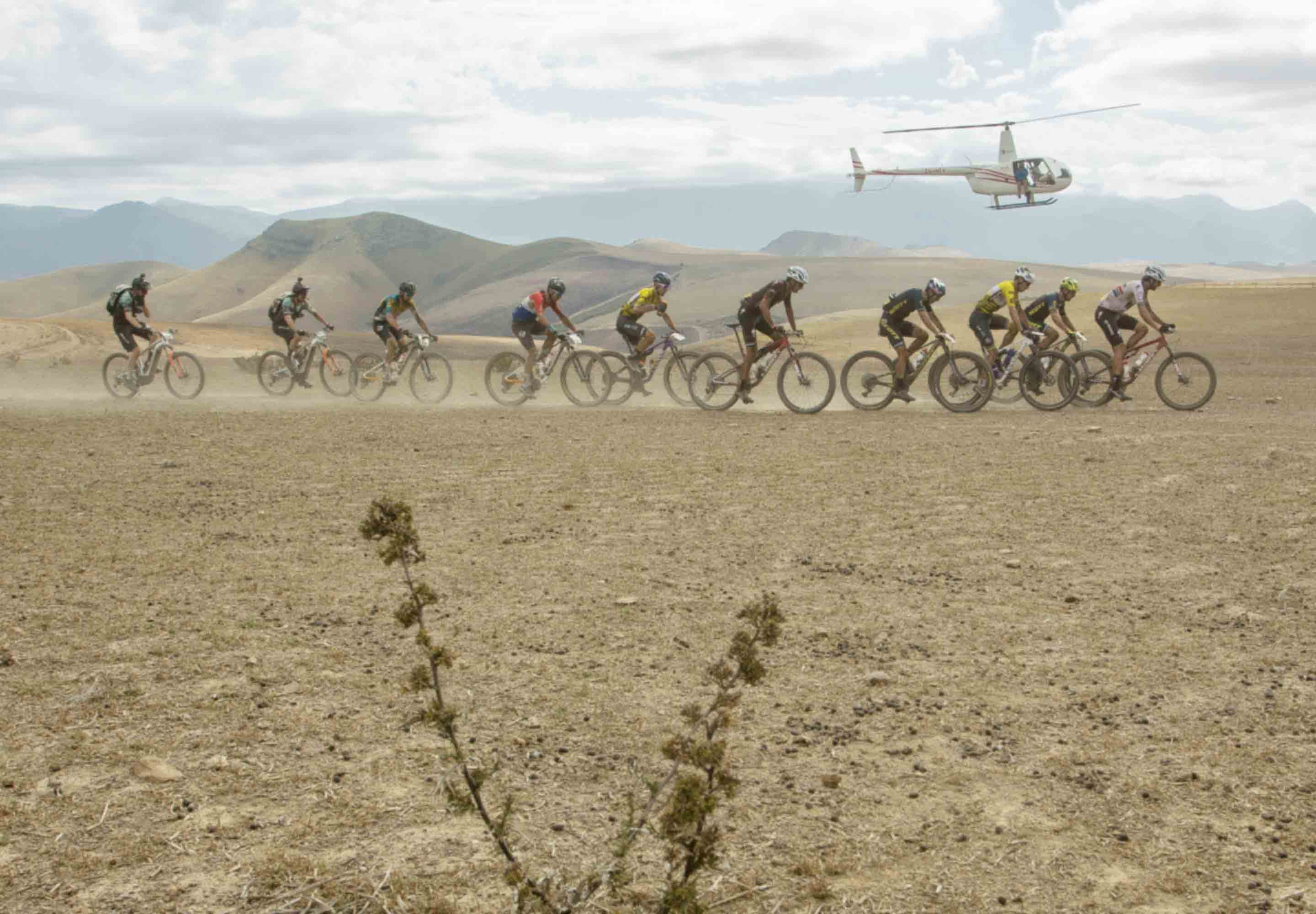 Absa Cape Epic mountain-bike riders racing with helicopter in background