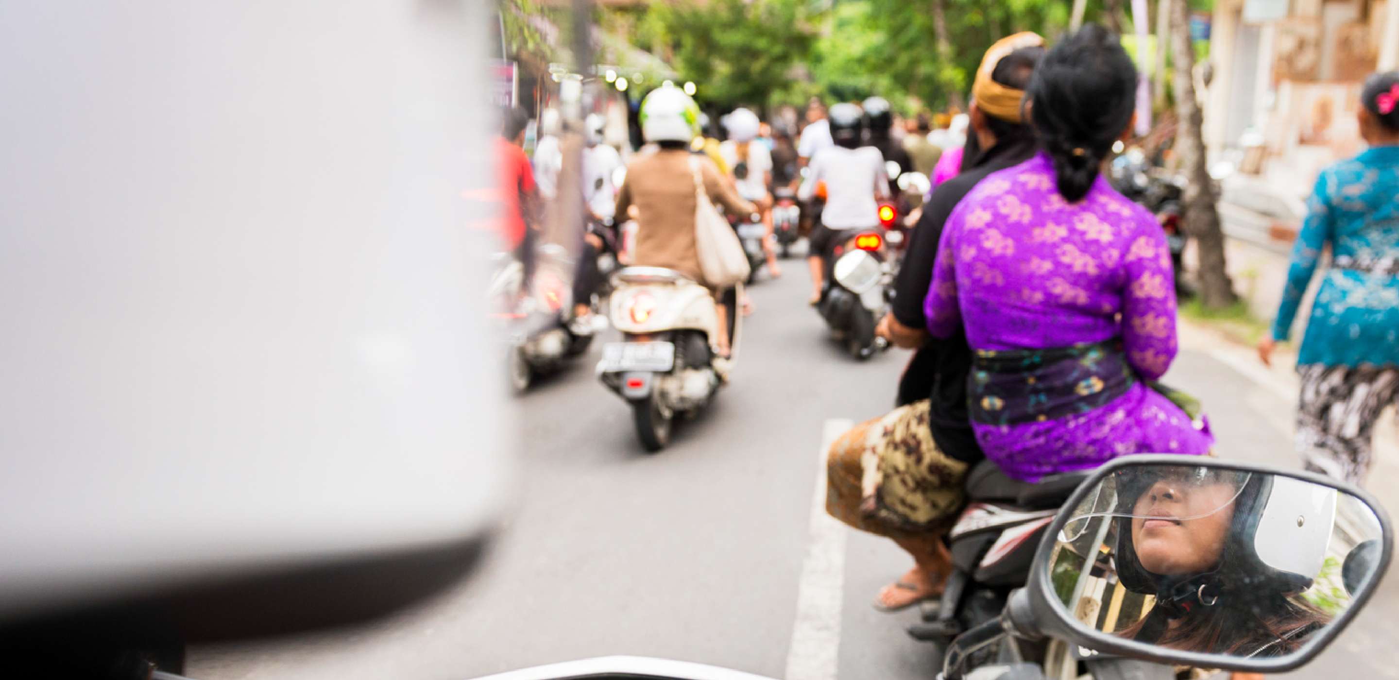 Back view of people riding motor bikes on the road