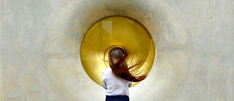 Woman standing in front of metallic orb