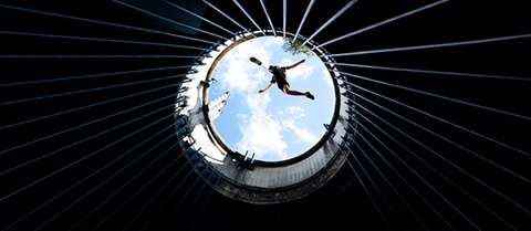 Man jumping over the top of a silo