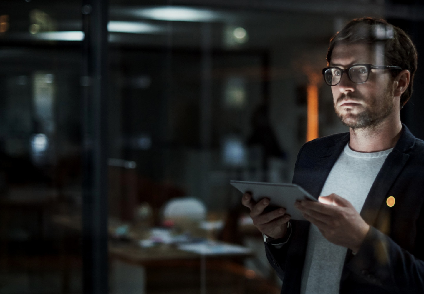 Man with tablet in dark office