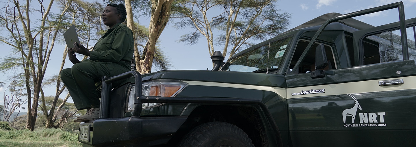 A Kenyan park ranger sitting on a park vehicle