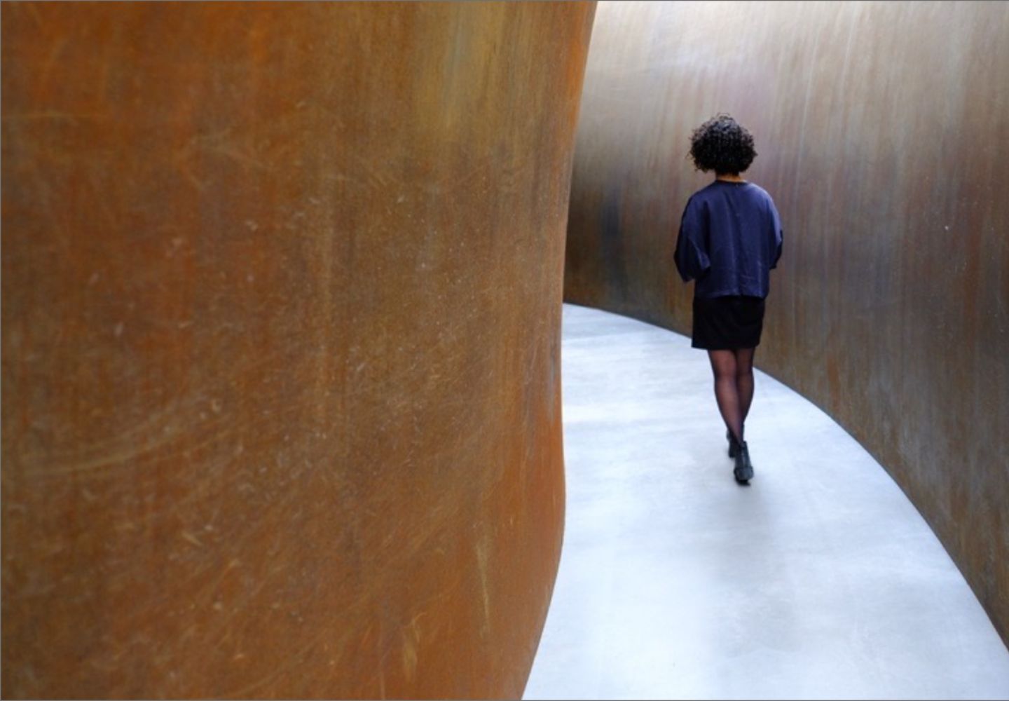 Woman walking down a curved corridor
