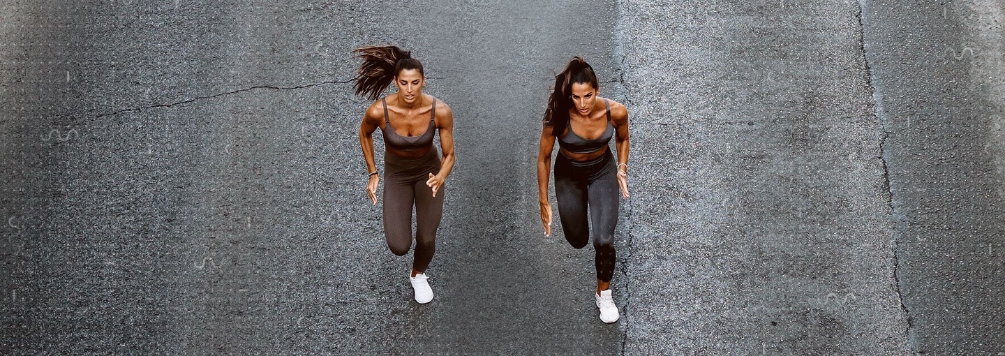 Two women running on a road